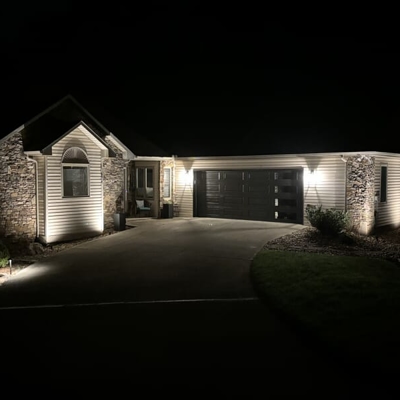 Lit up house and garage at night Photo